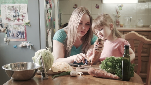 Mother Peeling Carrot With Daughter