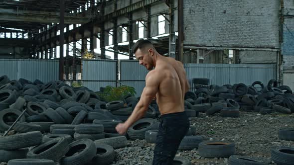 Shirtless bodybuilder in abandoned place.