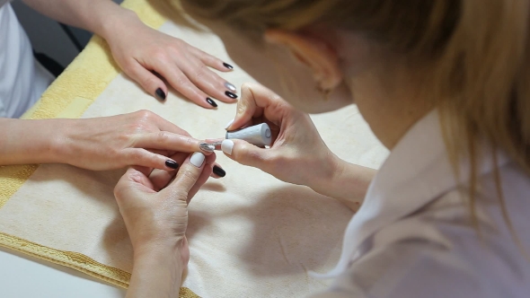 Woman Gets a Manicure Procedure In Spa Salon 