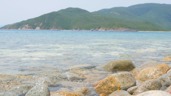 Stones Under The Waving Sea Water, Tropical Island On Background