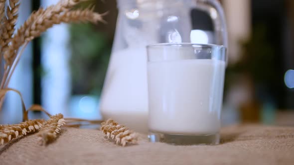 Milk In A Cursin And In A Glass On A Rustic Background, A Natural Milk Drink In A Glass On A Straw