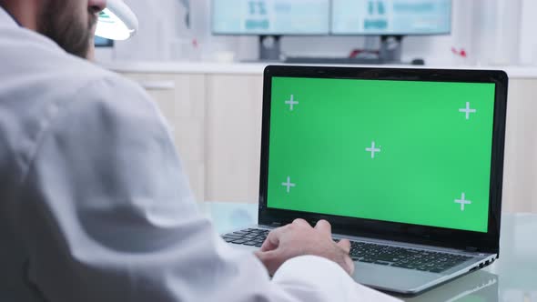 Doctor Works on Laptop with Green Screen