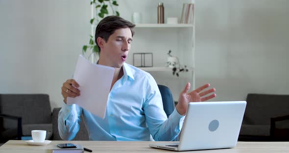 Young Business Student Boss Sits at Table at Paperwork, Dances By Hands, Celebrates End of Working