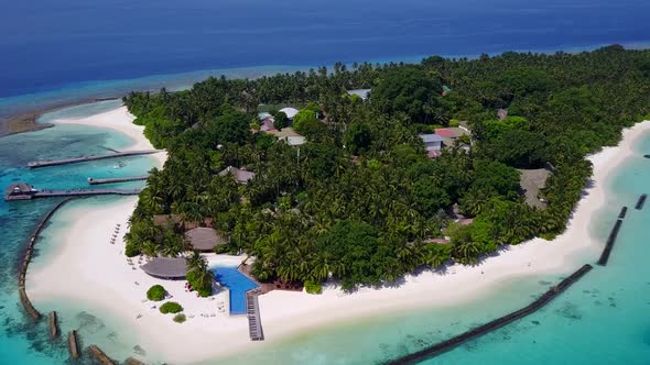 Aerial drone panorama of resort beach break by blue ocean with sand background