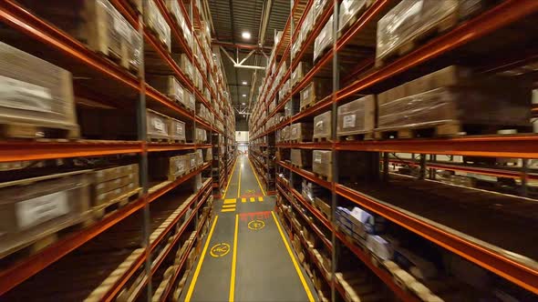 Motion Through Aisle Between High Racks with Product Boxes