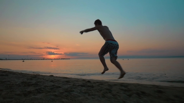 Man Making Cartwheel At Sunset