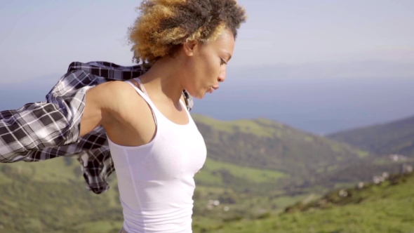 Woman With Open Arms On Coastal Hill Top