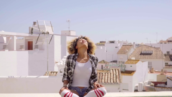 Woman Meditating On Rooftop