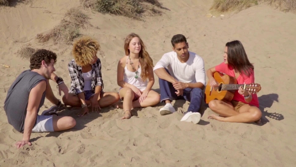 Group Of Young Multiracial Friends Playing Guitar