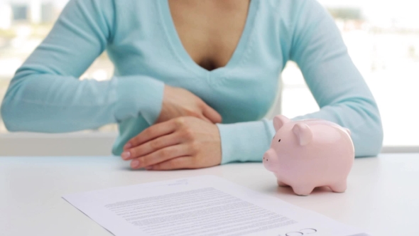 Woman Putting One Euro Coin Into Piggy Bank 65