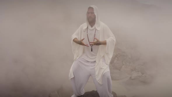 A Male Adult Outfit Swings His Body in an Up and Down Motion While Meditating