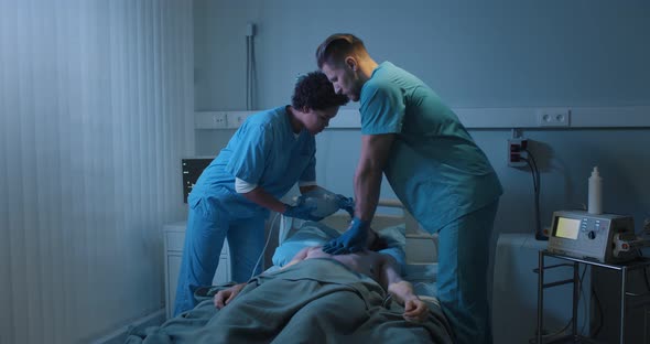 Doctors Putting an Oxygen Mask on Patient and Doing Cardiac Massage in Hospital