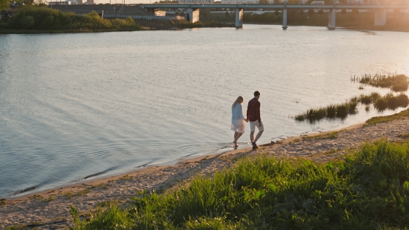 Yong Couple Walking On The Beach