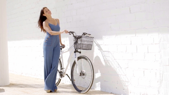 Elegant Young Woman Holding a Bicycle