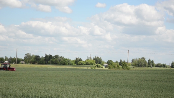 Tractor Spray Pesticide On Cultivated Field