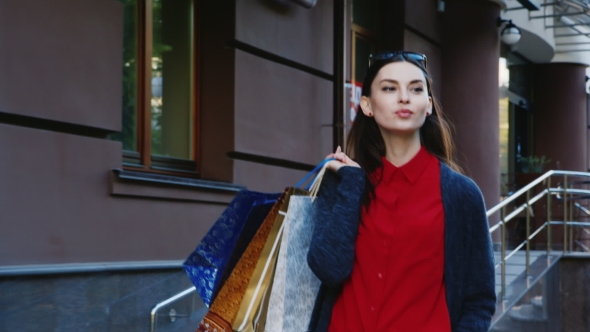 Stylish Woman Model Looks Goes Through The City With Shopping Bags