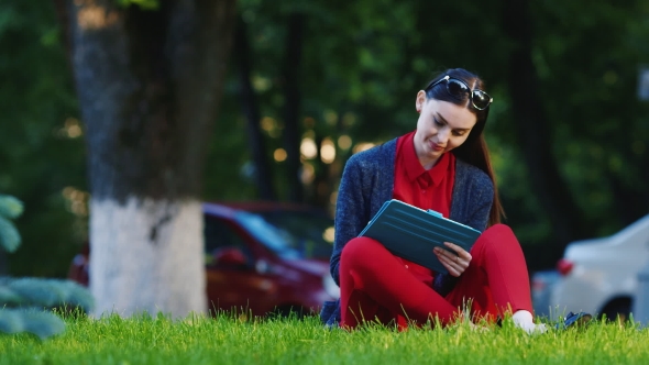 Internet And The Device Is Always With You. Woman Enjoys The Tablet Outdoors