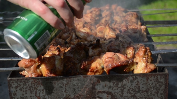 Hand Pour Beer On Meat Bake On Steel Spit Skewer Smoke Brazier