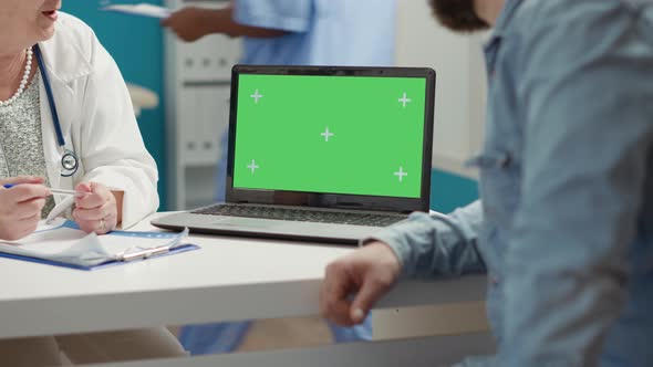 Young Adult and Medic Using Laptop with Greenscreen at Checkup Visit