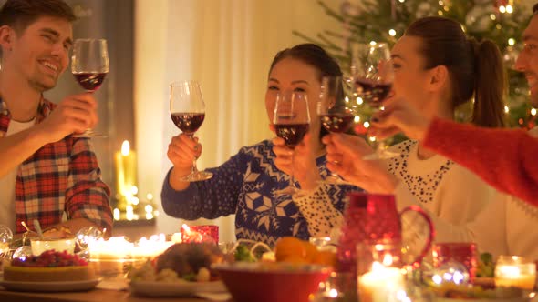 Happy Friends Drinking Red Wine at Christmas