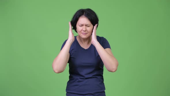 Stressed Woman Covering Ears From Loud Noise