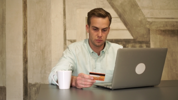 Young Handsome Man Buying With Computer And Credit Card.