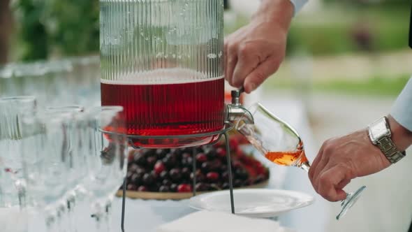 Waiter Fills Up a Glass with Some Rose Wine From a Decanter