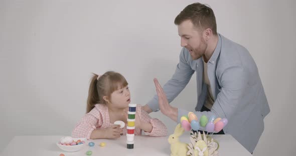 Girl with Down Syndrome Painting Easter Eggs with Father