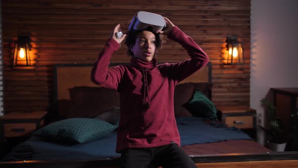 Mixed Race Boy Taking Off VR Glasses During Game