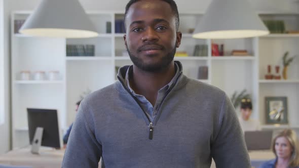 Young man smiling to camera at the office