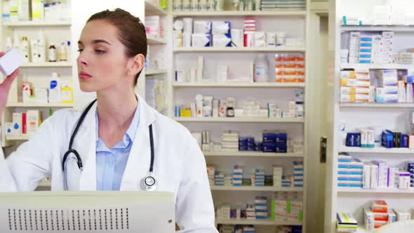 Pharmacist making prescription record on computer