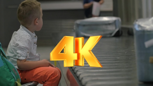 Child Waiting At The Baggage Claim Area