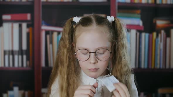 Small Girl Cribbing From Paper During Exam