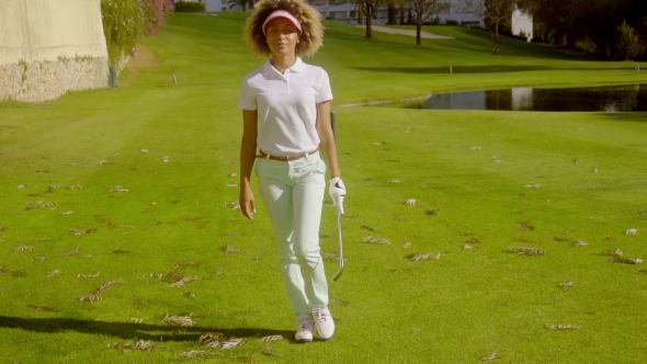 Young Woman Golfer In Front Of a Lake On a Course