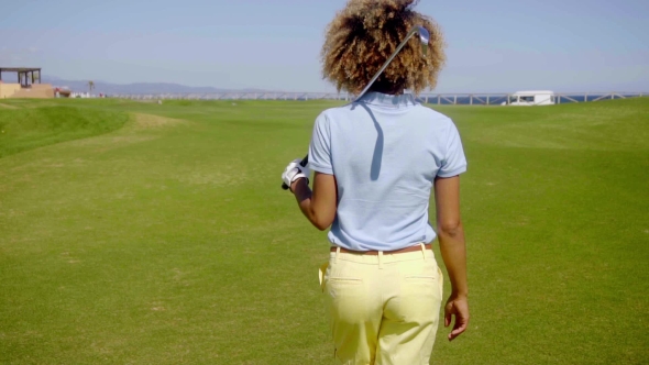 Female Golfer Walking Down a Fairway