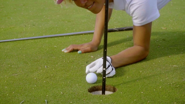 Smiling Young Woman Cheating At Golf