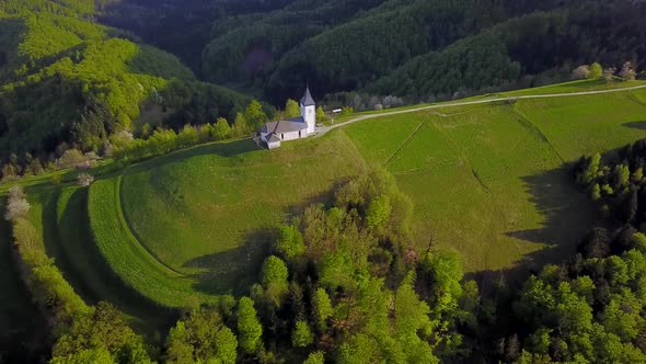 drone footage sunset at Church of St. Primus and Felician, Jamnik, Slovenia