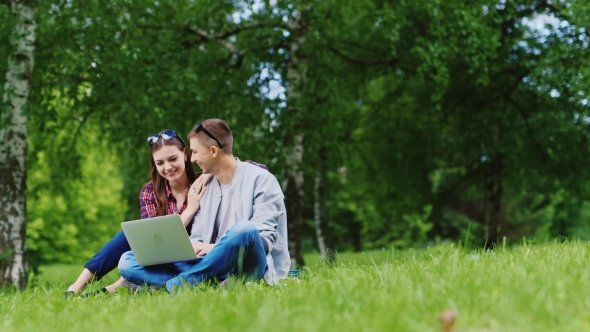 With Technology On Nature - a Couple With a Laptop In The Park