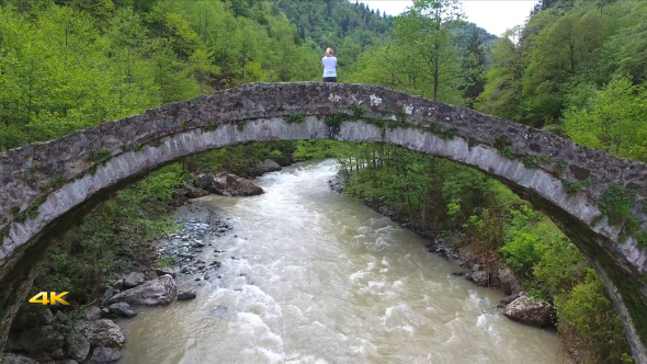 Aerial Woman Watching from Historic Stone Bridge