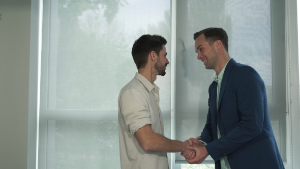 Two Young Professional Men Greeting With Handshake.