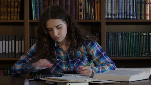 A Student Preparing For The Exam In The Library.  alt