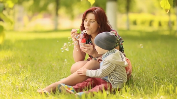 Young Mother And Baby Blow Bubbles