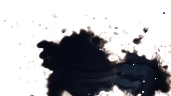 Black ink dropped over a white background