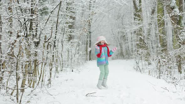 Happy Child Girl Playing With Snow on Snowy Winter Walk