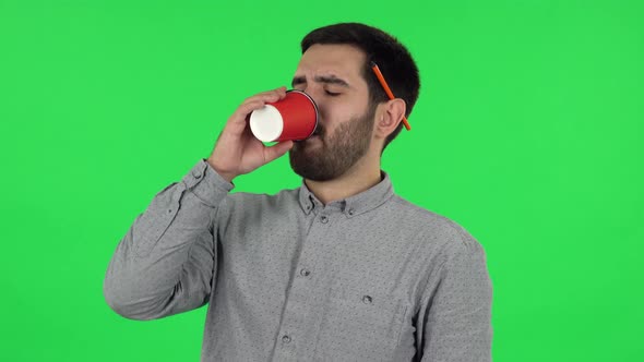 Portrait of Brunette Guy Drinking Unpalatable Coffee and Is Disgusted. Green Screen