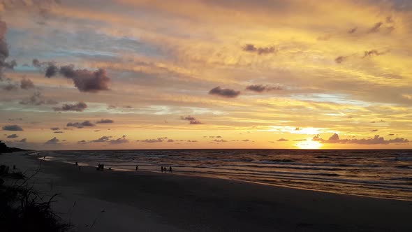 Sunset at the Lubiatowo Beach, Baltic Sea, Poland. Beautiful colours. People walking in the distance