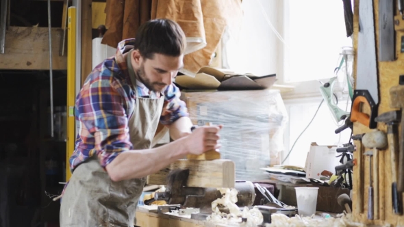 Carpenter Working With Plane And Wood At Workshop 11