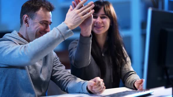 Cheerful Happy Caucasian Man and Woman Giving Highfive Coding Application or Hacking Website