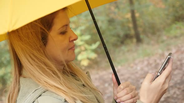 Slow motion of lifestyle female on mobile phone while holding yellow umbrella outdoor 1920X1080 HD f