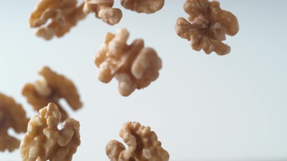 Camera follows walnuts in shell rolling on the table. Slow Motion.